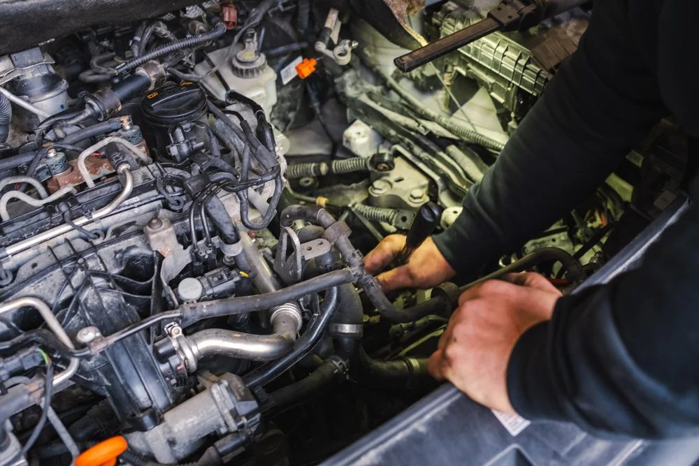 Mekaniker arbeider i motorrommet på en bil